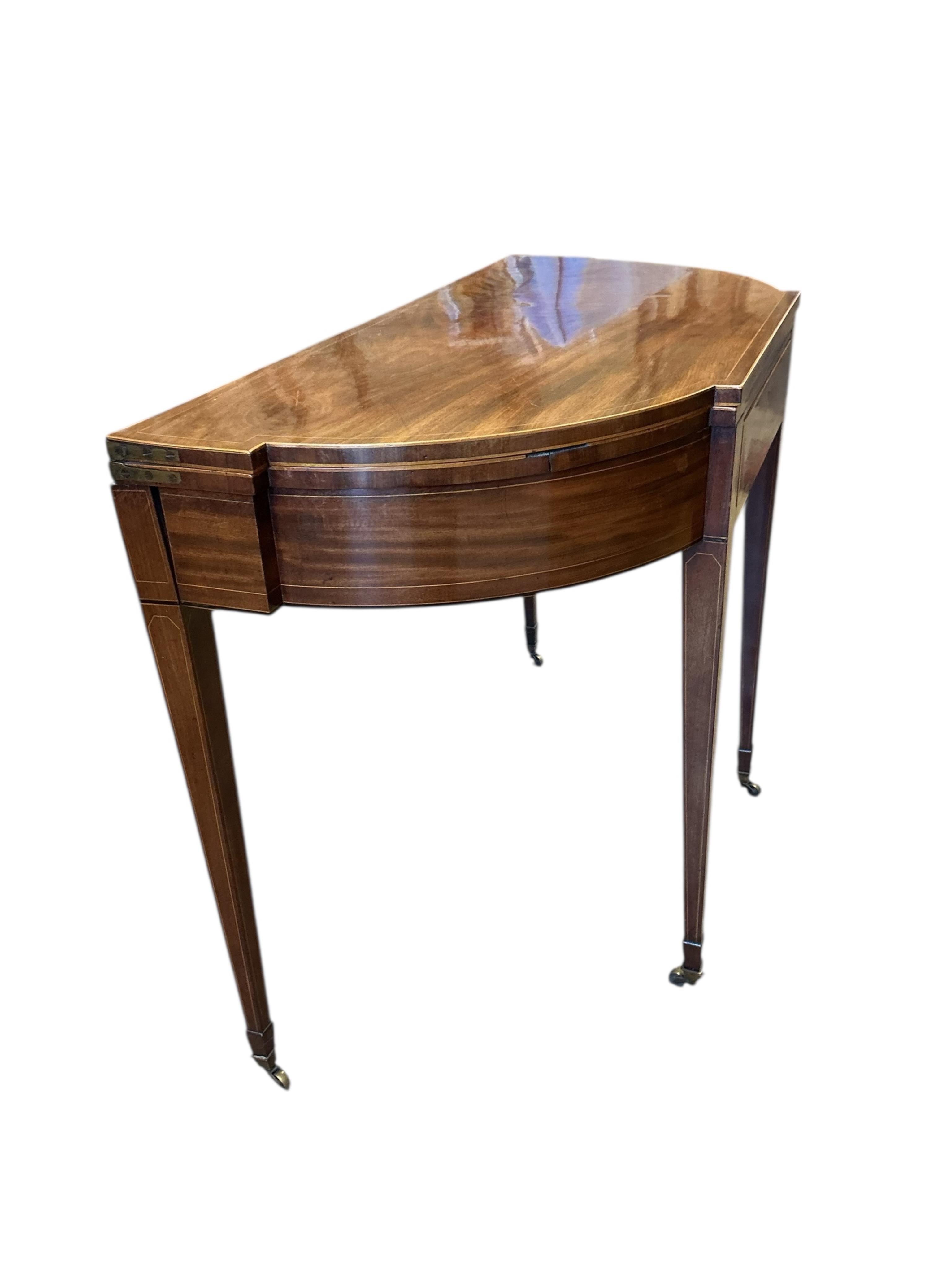 A George III boxwood strung mahogany breakfront folding tea table with frieze drawer, width 101cm, depth 47cm, height 74cm